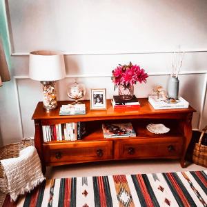 a table with a lamp and flowers on top of it at Suítes Apoena in Arraial do Cabo