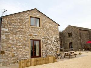 a stone building with a picnic table in front of it at Clerk Laithe Lodge in Newton