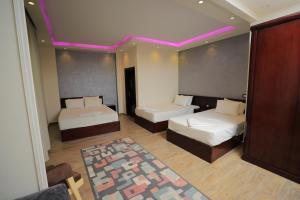 a room with two beds and a purple lighting at Jewel Grand Museum & Pyramids View in Giza