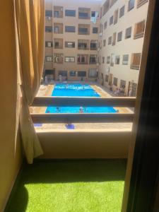 een raam met uitzicht op een groot zwembad bij Glamorous Marrakech in Marrakesh