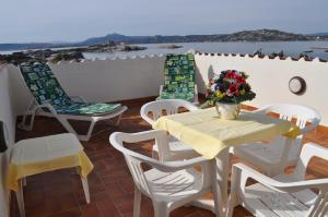 a dining room table with chairs and umbrellas at Hotel Nido D'aquila in La Maddalena