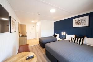 um quarto de hotel com duas camas e uma mesa em Southend Hotel em Sidney