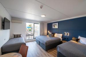 um quarto de hotel com duas camas e uma janela em Southend Hotel em Sydney