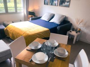 a room with a bed and a table with plates on it at [Paradis 401] T2 apaisant au coeur de Lourdes in Lourdes