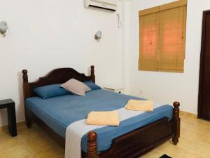 ein Schlafzimmer mit einem Bett mit blauen Laken und einem Fenster in der Unterkunft Hikka Villa in Hikkaduwa + 36 Fotos
