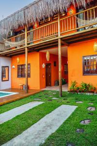 an orange house with a pool and a balcony at Pousada Casa Joana Trancoso in Trancoso
