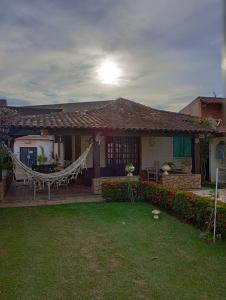 una casa con una hamaca en el patio delantero en Casa da Lua en São Pedro da Aldeia