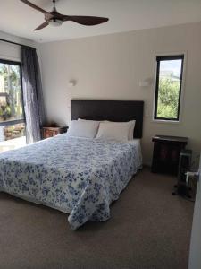 - une chambre avec un lit et un ventilateur de plafond dans l'établissement Paradise In Whitianga B & B, à Whitianga