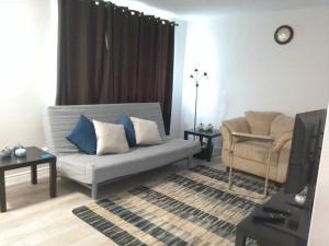 uma sala de estar com um sofá e uma cadeira em Sweethome - 10 min to Rogers Place & so much more em Edmonton