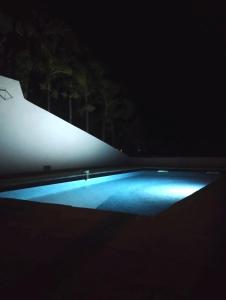 a swimming pool at night with a blue light at Bas de villa vue mer avec deux chambres in Grand-Bourg