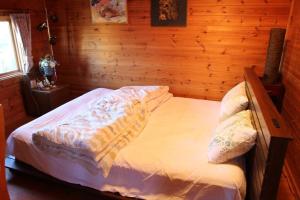 - une chambre avec un lit dans une pièce en bois dans l'établissement Log house Tomi-chan's house / Private building, à Echizen