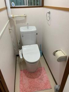 圖卡塔的住宿－ステイビレッジ蔵王　一棟丸貸し宿泊施設4名様まで同一金額　ペット同伴可！，一间带卫生间的小浴室,铺有粉红色地毯
