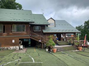 a large wooden house with a parking lot in front of it at ステイビレッジ蔵王　一棟丸貸し宿泊施設4名様まで同一金額　ペット同伴可！ in To-katta