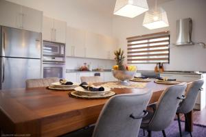 a kitchen with a wooden table with chairs around it at Tropical Villa Rainville in Paramaribo