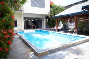 a swimming pool in the backyard of a house at Tropical Villa Rainville in Paramaribo