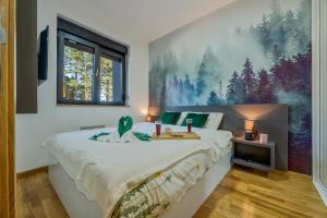 a bedroom with a large bed with a painting on the wall at Apartman Maska in Zlatibor