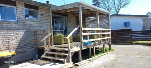 a house with a wooden staircase leading to a porch at Papamoa Budget Accommodation in Papamoa