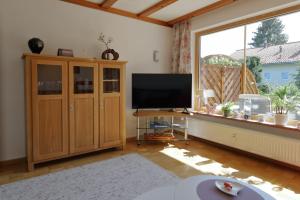 a living room with a television and a large window at Ferienhaus Haas inkl. Chiemgaukarte in Ruhpolding