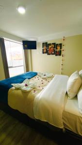 Un dormitorio con una cama grande con flores. en Hotel Valle Andino en Cusco