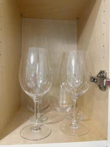 three wine glasses sitting on top of a shelf at Haven Tree Sweet Home in Richmond