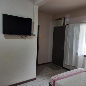 Habitación con TV de pantalla plana en la pared en Aptos Enseada Prox Praia en São Francisco do Sul