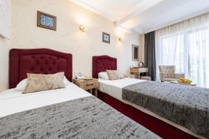 een hotelkamer met 2 bedden en een raam bij Konur Hotel in Ankara