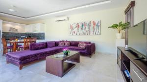 - un salon avec un canapé violet et une table dans l'établissement Athena 2 Romantic 1br Pool Villa SANUR, à anur
