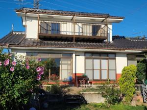 una casa con balcone sopra di Guesthouse Hidamari no Yado - Vacation STAY 04353v a Tomi
