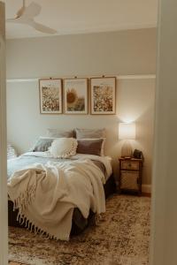 1 dormitorio con 1 cama y 1 mesa con lámpara en Linden Cottage Farm Stay, en Harden