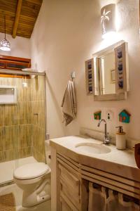 a bathroom with a toilet and a sink and a shower at Pousada Casa Joana Trancoso in Trancoso