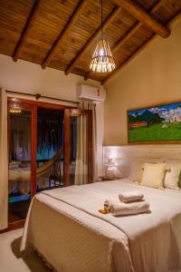 a bedroom with a large bed with towels on it at Pousada Casa Joana Trancoso in Trancoso