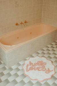 una vasca rosa in bagno con tappeto di Linden Cottage Farm Stay a Harden