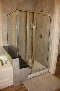 a shower with a glass door next to a sink at 4 Bedroom - Luxury Home and Bedding -Sleeps 9 in Humble