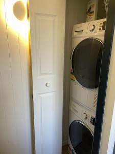 eine Küche mit einer Mikrowelle, einer Waschmaschine und einem Trockner in der Unterkunft The Cottage in Queenstown
