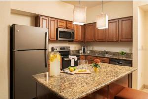 een keuken met een granieten aanrecht en een koelkast bij Floriday Resort in Orlando