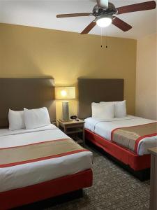 ein Hotelzimmer mit 2 Betten und einem Deckenventilator in der Unterkunft Floriday Resort in Orlando