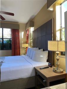 ein Schlafzimmer mit einem großen Bett und einem Tisch mit einer Lampe in der Unterkunft Floriday Resort in Orlando