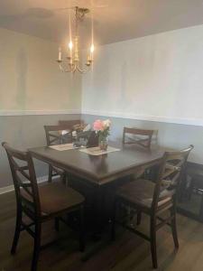 una mesa de comedor con sillas y un jarrón de flores en Disney Kissimmee Condo, en Kissimmee 5 fotos más
