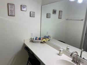 Un baño con lavabo y un espejo grande. en Disney Kissimmee Condo, en Kissimmee