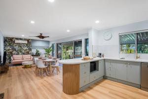 eine Küche und ein Wohnzimmer mit einem Tisch und Stühlen in der Unterkunft Deco View Family Oasis in Cairns in East Trinity