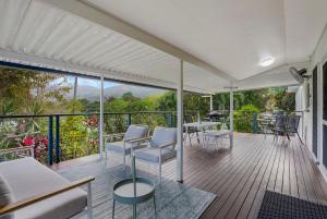 eine Veranda mit einem Tisch und Stühlen auf einer Terrasse in der Unterkunft Deco View Family Oasis in Cairns in East Trinity