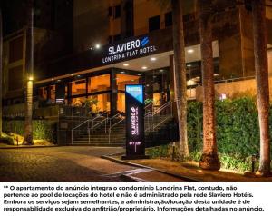 a sign in front of a building at night at FLAT LUXO PREMIUM - Londrina Flat Hotel - 43m² #garagemgrátis in Londrina