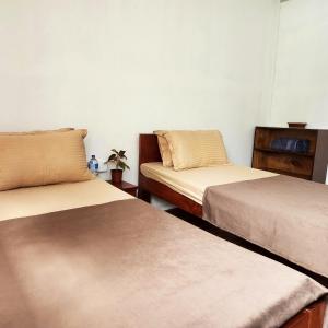 BeniにあるThe Heritage at Lamakhet Hotelのベッド2台とテーブルが備わる客室です。