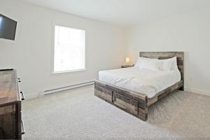 a white bedroom with a bed and a television at Idyllic & Cozy Stylish Belmont Haven near Lewiston - 1BR 1BA Apartment in Auburn