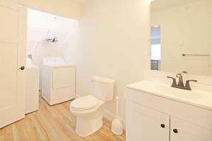 Baño blanco con aseo y lavamanos en Idyllic & Cozy Stylish Belmont Haven near Lewiston - 1BR 1BA Apartment, en Auburn