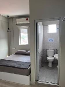 um pequeno quarto com uma cama e um WC em Sunshine House em George Town