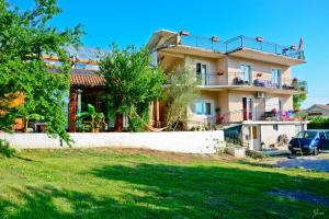 a house with a car parked in front of it at Hostel Anton in Tivat