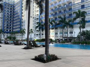 - une piscine bordée de palmiers et de bâtiments dans l'établissement Sea Residences by EXIN, à Manille