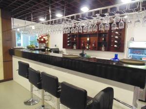 - un bar avec des chaises noires et des verres à vin dans l'établissement Sport Hotel HN - by BAY LUXURY, à Hanoï 10 autres photos