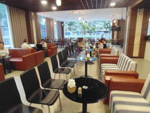 - un restaurant avec des chaises, des tables et des tables dans l'établissement Sport Hotel HN - by BAY LUXURY, à Hanoï